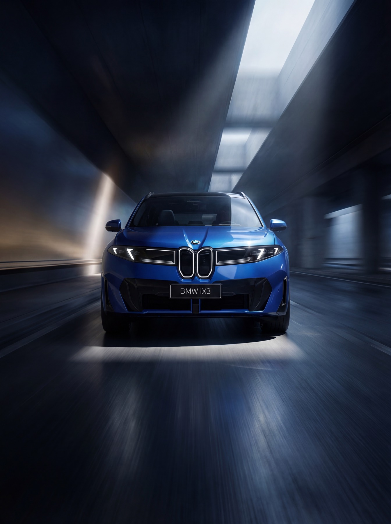 Blue BMW iX3 driving through a cinematic tunnel