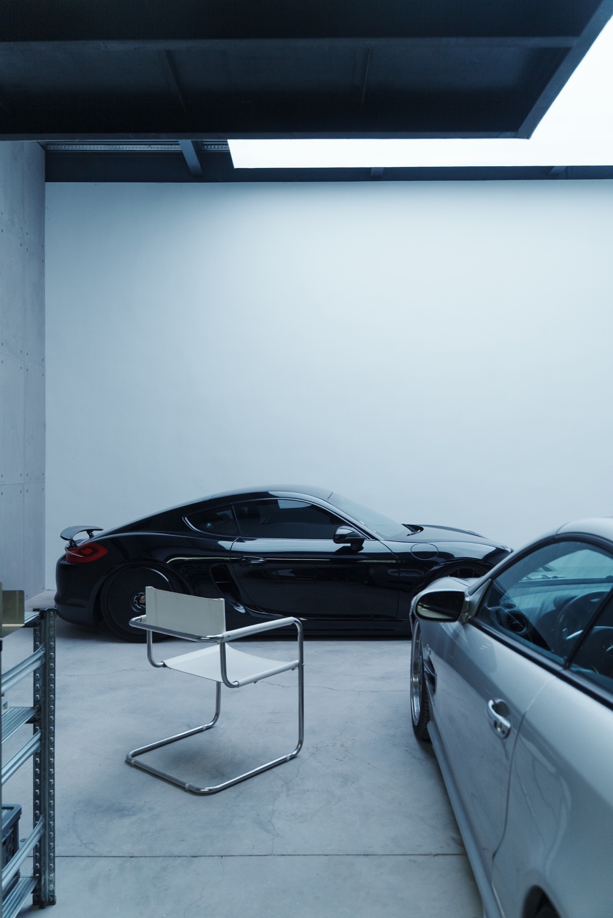 Black car and chair in a minimal garage studio