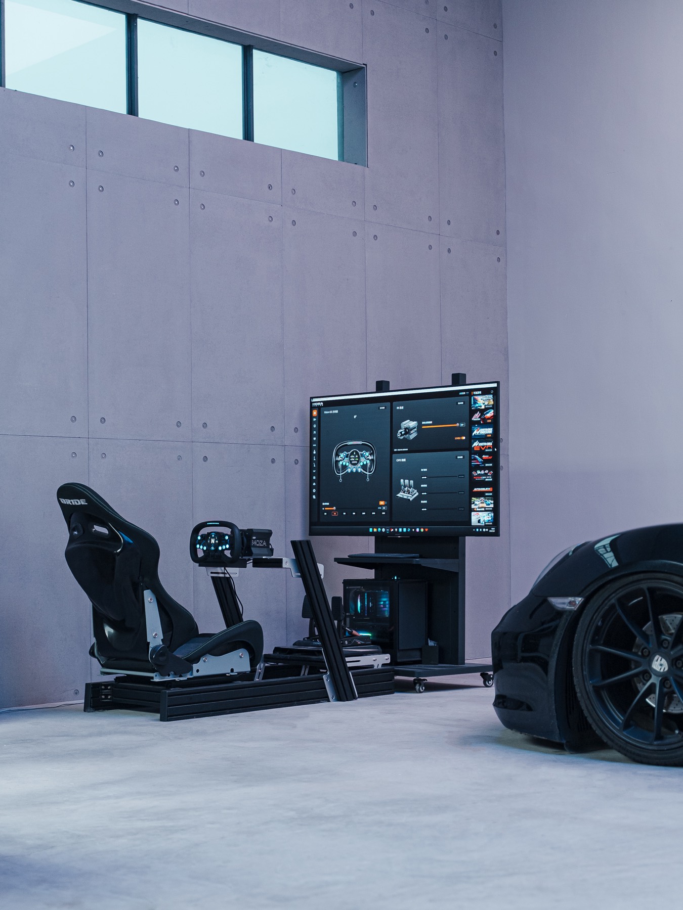 Driving simulator and black car beside concrete wall